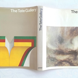 May include: An open book with the text "The Tate Gallery" on the cover and spine. The left side features a colorful abstract design with green, red, and yellow shapes. The right side displays a muted, abstract painting.