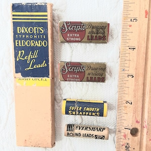 Może przedstawiać: Asortyment wkładów do ołówków w stylu vintage, w tym Dixon's Typhonite Eldorado, Scripto Drawing Leads, Super Smooth Sheaffer's i Eversharp Round Leads. Drewniana linijka znajduje się obok wkładów.