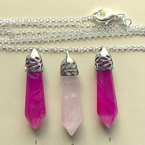 May include: Three silver pendant necklaces with different colored gemstone drops. The first pendant is a pink and white agate, the second is a light pink rose quartz, and the third is a pink and white agate. The pendants are numbered 1, 2, and 3.