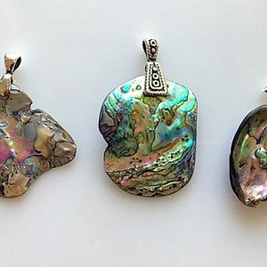 May include: Three iridescent abalone shell pendants with silver bail attachments. The shells are different shapes and sizes, with a variety of colors and patterns.