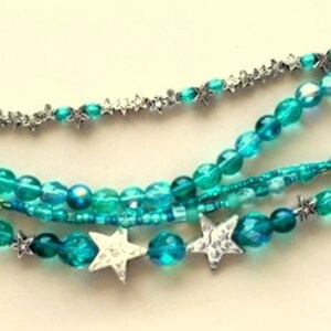 May include: Multi-strand bracelet with turquoise blue beads and silver star charms.