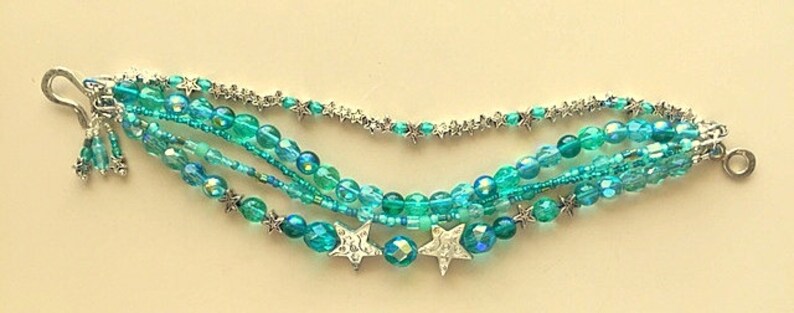 May include: Multi-strand bracelet with turquoise and silver beads, featuring star-shaped charms.