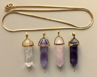 May include: Four gold-plated crystal point pendants on a gold chain. The pendants are clear, amethyst, rose quartz, and amethyst. The pendants are numbered 1 through 4.