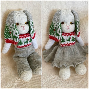 Könnte beinhalten: Eine weiße gestrickte Hasenpuppe, die einen grün-roten Weihnachtspullover und einen grauen Rock trägt. Die Puppe hat ein weißes Gesicht mit orangefarbenen Augen und einer rosa Nase.