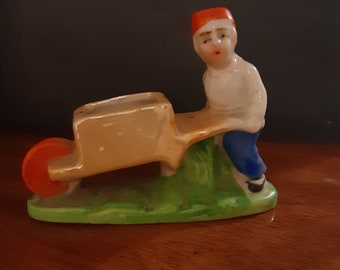 Simply cute porcelain boy pushing a cart made in Japan