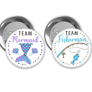 May include: Two round button pins with white backgrounds and colorful designs. One pin features a purple and blue mermaid tail with the text "TEAM Mermaid". The other pin features a blue fishing rod with a fish and the text "TEAM Fisherman".