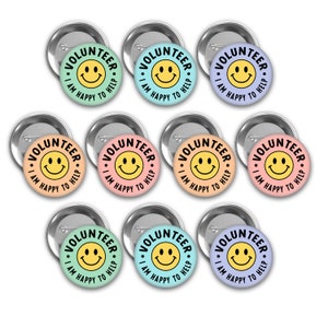 May include: Nine round buttons with a silver backing. Each button has a different pastel colored background. The buttons have a black and white smiley face with the text "Volunteer. I am happy to help."
