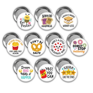 May include: Set of ten 1 inch button pins with various colorful designs and positive messages. The pins feature illustrations of a bee, pretzels, french fries, donuts, a can of soda, stars, and a s'more. The messages include "Bee Positive", "Spread Kindness", "Don't Be Salty", "Never Give Up", "Fry and Fry Again", "Here's a Little Encourage Mint", "Donut Stop Believing", "Dream Big Make it Happen", "Yes! You Can", and "Shine Like the Stars".