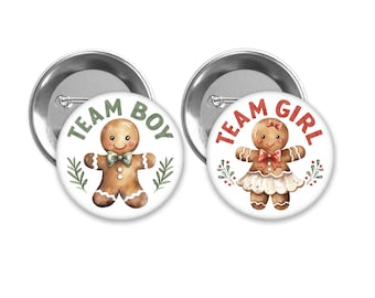 Może przedstawiać: Dwa guziki w kształcie piernikowego ludzika, jeden z napisem "Team Boy" i piernikowym chłopcem, drugi z napisem "Team Girl" i piernikową dziewczynką.