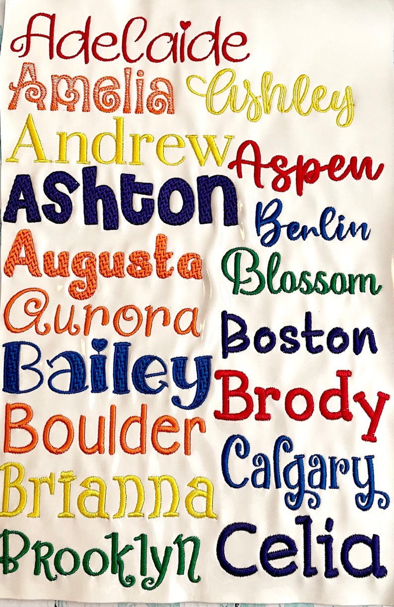 Pode incluir: Um fundo branco com um arco-&iacute;ris de nomes bordados, incluindo Adelaide, Amelia, Ashley, Andrew, Aspen, Ashton, Berlim, Augusta, Blossom, Aurora, Boston, Bailey, Brody, Boulder, Brianna, Calgary e Brooklyn Celia.