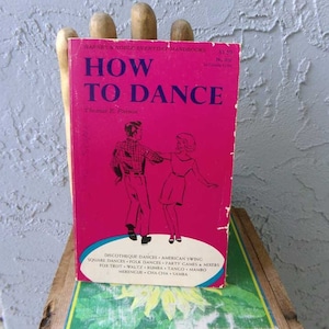May include: A pink paperback book titled "How to Dance" by Thomas E. Parson. The cover features a black and white illustration of a couple dancing. The book is part of the Barnes & Noble Everyday Handbooks series.