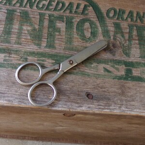 May include: A white ceramic mug with a black handle and the text "But First, Coffee" in a bold, black font. The mug is set against a neutral background, highlighting its simple design.