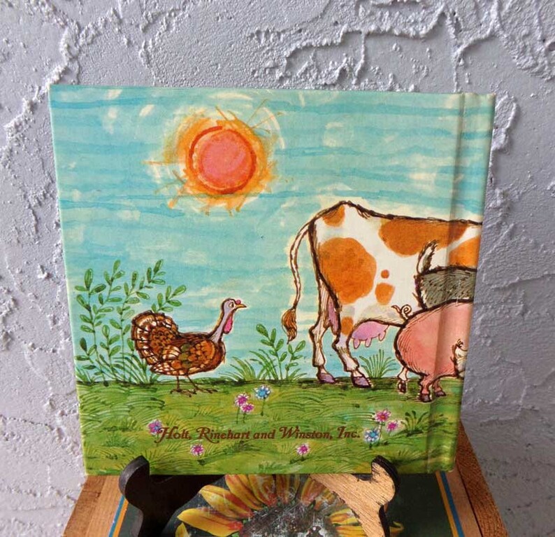 May include: A vintage children's book cover with a watercolor illustration of a cow, pig, and turkey in a field. The sun is shining in the blue sky. The book is published by Holt, Rinehart and Winston, Inc.