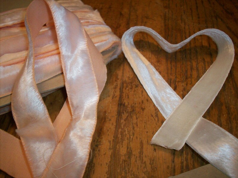 May include: Two rolls of pink velvet ribbon with a satin sheen. One roll is folded into a heart shape.