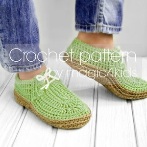 Puede incluir: Patrón de crochet de magic4kids. Un par de zapatillas de crochet verde con suela marrón. Las zapatillas son usadas por una persona que lleva pantalones vaqueros azules.