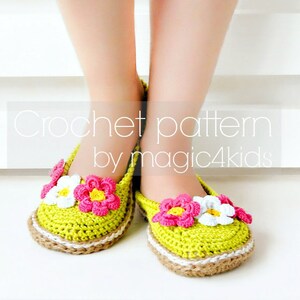 Puede incluir: Pantuflas de ganchillo con un diseño floral en tonos de rosa, blanco y amarillo. Las pantuflas son verdes y tienen un ribete marrón. El texto "Crochet pattern by magic4kids" es visible en la imagen.