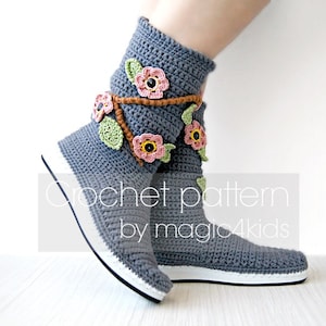 May include: Gray crochet boot with a white sole and a floral design. The boot has pink, brown, and green flowers crocheted onto it. The text "crochet pattern by magic4kids" is visible below the boot.