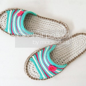 Puede incluir: Un par de zapatillas de crochet con un diseño a rayas en blanco, turquesa y rosa. Las zapatillas tienen un ribete de crochet marrón y un pequeño acento de flor rosa.