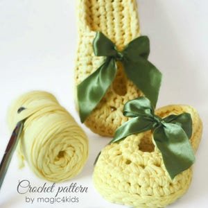 May include: Two pairs of yellow crocheted baby shoes with green bows. The shoes are made with a simple stitch pattern and have a delicate, feminine look. Crochet pattern by magic4kids.