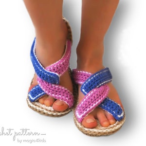 May include: Crocheted sandals with pink and blue straps, white trim, and a natural jute sole. The sandals are being worn on a pair of feet.