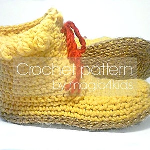 Puede incluir: Pantuflas de color amarillo tejidas a crochet con ribete marrón y cordones rojos. Las pantuflas son hechas a mano y tienen una etiqueta que dice "Crochet pattern by magic4kids".