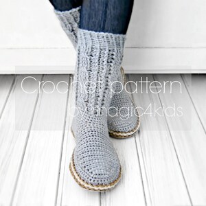 Puede incluir: Calcetines de lana grises hechos a crochet con ribete marr&oacute;n. Los calcetines los lleva puestos una persona con pantalones vaqueros azules. El texto "Crochet pattern by magic4kids" es visible en el suelo.