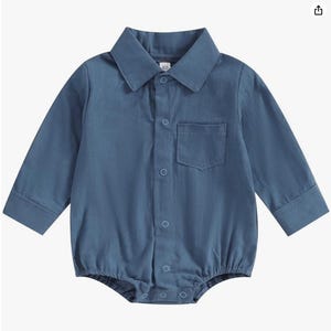 May include: A long-sleeved, blue collared bodysuit featuring a button-down front placket with visible circular buttons, a single chest pocket on the left side, and a size tag reading 60 at the inner neckline. The garment has a classic shirt style.