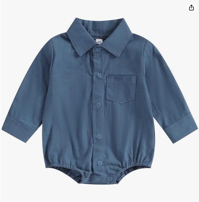 May include: A long-sleeved, blue collared bodysuit featuring a button-down front placket with visible circular buttons, a single chest pocket on the left side, and a size tag reading 60 at the inner neckline. The garment has a classic shirt style.