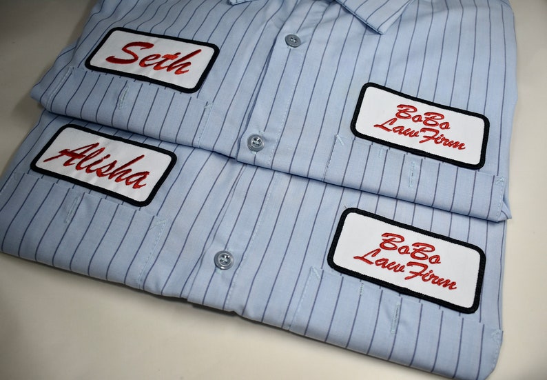 May include: Two blue striped shirts with white patches. The top shirt has a red embroidered name "Seth" and a white patch with the text "BoBo Law Firm". The bottom shirt has a red embroidered name "Alisha" and a white patch with the text "BoBo Law Firm".