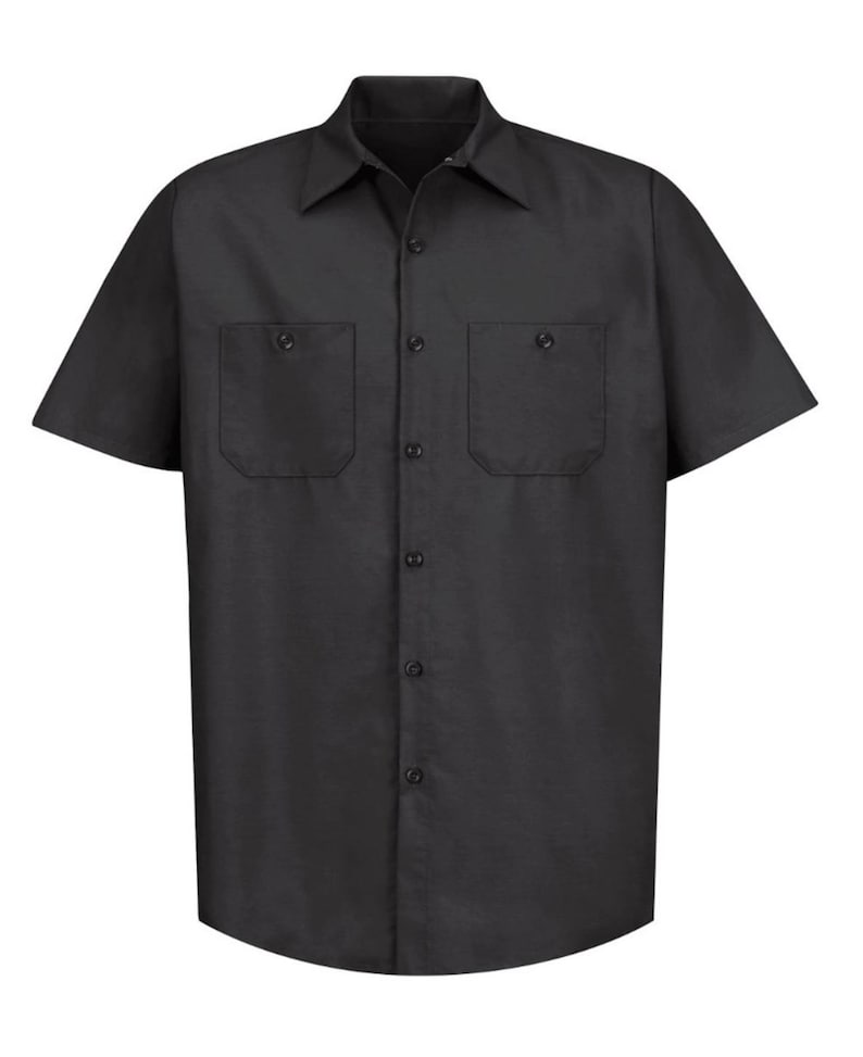 Puede incluir: Una camisa negra lisa de manga corta con cuello cl&aacute;sico, tapeta de botones frontal y dos bolsillos en el pecho con solapas abotonadas. La prenda est&aacute; confeccionada con un dobladillo recto y una apariencia estructurada y uniforme en todo su dise&ntilde;o.