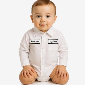 May include: A white long-sleeved button-down bodysuit featuring a classic collar and two rectangular patches on the chest. The left patch displays the text Name here, and the right patch displays the text Logo here, both in a black sans-serif font.