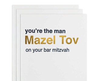 Puede incluir: Una tarjeta blanca con el texto "you're the man Mazel Tov on your bar mitzvah" en azul marino y lámina dorada.