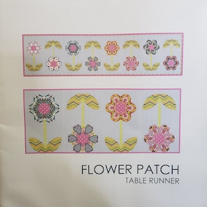 May include: A sewing pattern for a table runner featuring a floral design. The pattern is called "Flower Patch Table Runner" and is by Sue Daley Designs.
