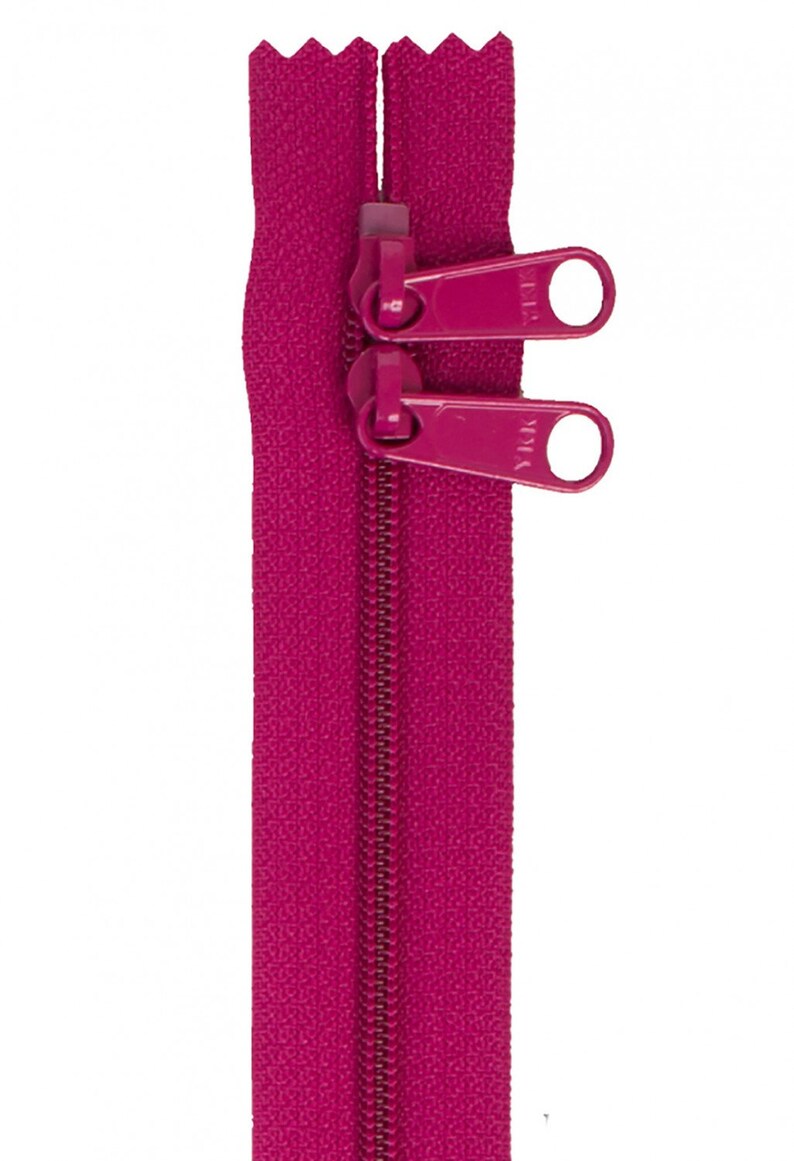 May include: A pink zipper with two pull tabs. The zipper is closed and the pull tabs are in the up position.