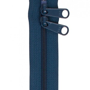 May include: A dark blue zipper with two pull tabs. The zipper is closed and the pull tabs are in the up position.