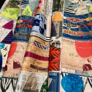 May include: A colorful fabric with a patchwork design featuring geometric shapes, maps, and text. The fabric is made of a soft, lightweight material and has a vintage feel.