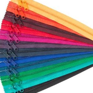 May include: A collection of colorful zipper tapes in various shades of red, orange, yellow, green, blue, and black. The zippers are arranged in a fan shape, with the top zipper being yellow and the bottom zipper being black.