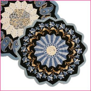 May include: Two blue and white quilted round table mats with a floral and paisley design.