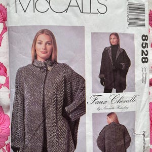 Puede incluir: Un patrón de costura para un abrigo de imitación de chenilla negro y blanco. El patrón es de McCall's y es el número 8528. El patrón incluye instrucciones para hacer un abrigo con cuello, mangas largas y cierre de botones.