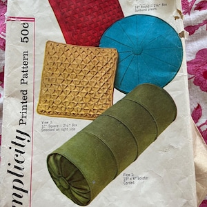 May include: A Simplicity sewing pattern for making four different pillows. The pattern includes instructions for a 12-inch square pillow, a 14-inch round pillow, a 12-inch square pillow, and an 18-inch by 8-inch bolster pillow. The pattern is for size 50c and is number 4515.