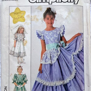 Könnte beinhalten: Simplicity Schnittmuster mit drei Kleiderdesigns für Mädchen. Das Hauptbild zeigt ein lila Kleid mit Spitzendetails und einem hellblauen Schärpe. Das Muster enthält Größen und den Text "made in heaven".