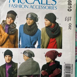 May include: A McCall's Fashion Accessories pattern featuring various hat and scarf designs. The image showcases different styles, including beanies and scarves, with models wearing the finished products. The pattern includes size OSZ.