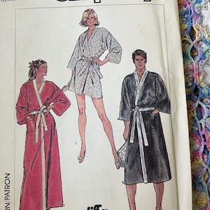 May include: A Simplicity sewing pattern envelope, number 7441, size LG. The front features illustrations of three robe styles: a long red robe, a short floral print robe, and a mid-length black robe, all with contrasting trim and waist ties.