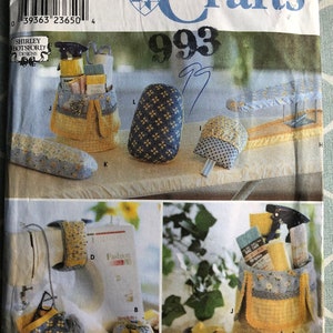 May include: A Simplicity Crafts sewing pattern envelope, number 9076, featuring illustrations of various fabric organizers, pincushions, and sewing accessories in blue and yellow floral and checkered patterns with visible text and branding.