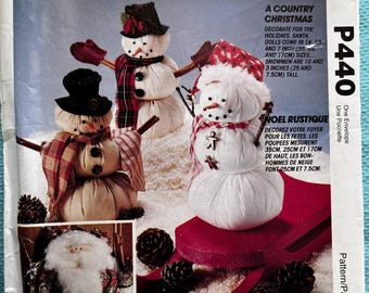 Può includere: Un cartamodello per cucire un pupazzo di neve e una bambola di Babbo Natale a tema natalizio country. Il cartamodello include istruzioni per realizzare un pupazzo di neve con un cappello rosso e una sciarpa, una bambola di Babbo Natale con un cappello rosso e una barba bianca, e un pupazzo di neve su una slitta rossa. Il cartamodello si chiama "A Country Christmas" e il numero del cartamodello è P440.