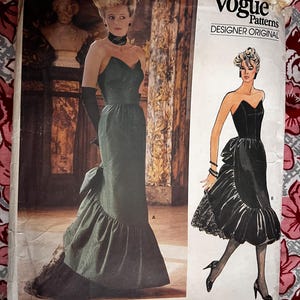 May include: Vogue Patterns Designer Original sewing pattern for a black and green evening gown with a ruffled skirt. The pattern number is 1471. The designer is Bellville Sassoon.