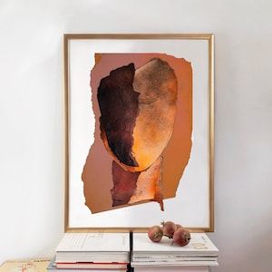 A dramatic, brown-orange golden framed art print of an abstract head in all shades of dark wood and blazing orange. A reddish spot spills out the torn paper, random-shaped Halloween pumpkin background. The wall art is arranged on a pile of books.