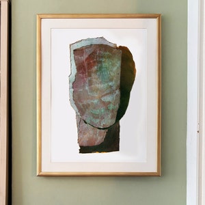 May include: A framed abstract art print with a textured, layered, and colorful design. The artwork features a large, central shape resembling a head or face, with shades of green, brown, and red.