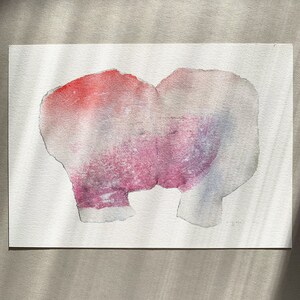 A high quality art print of a romantic abstract portrait of a kiss in off white, coral and lavender blush pink and pastel violet on white. It's composed of one piece torn paper with rough edges, accented with fine spray-painted bluish mist.