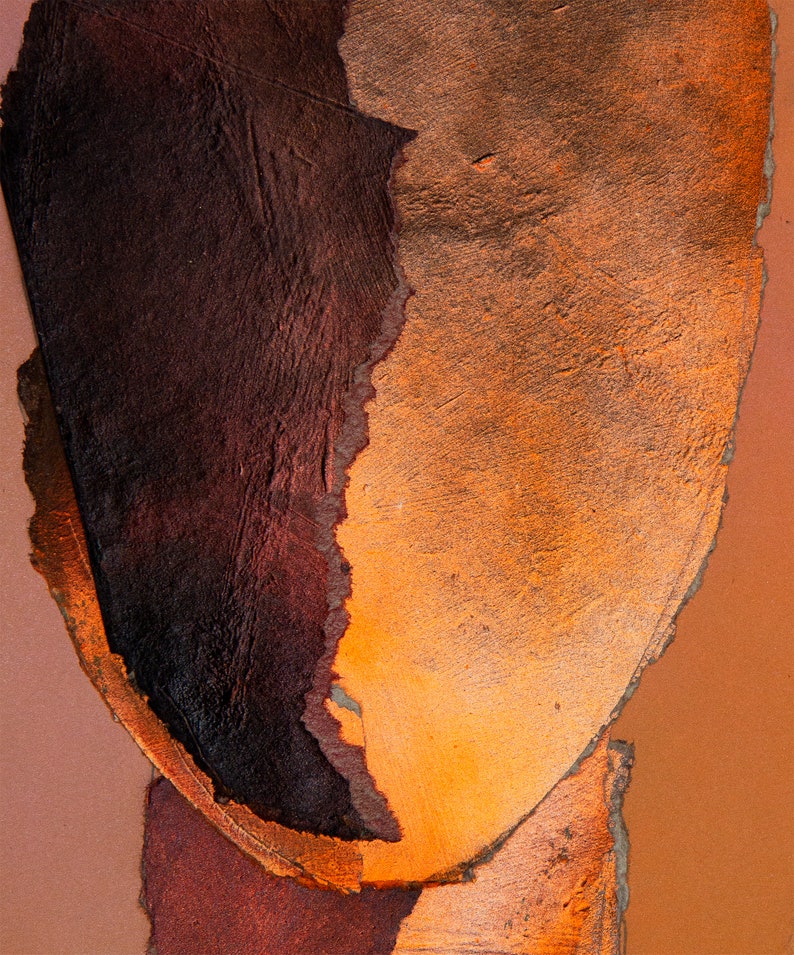 A dramatic detail of a vivid brown-orange  abstract head in all shades of dark wood and blazing orange. A reddish drop spills out from the torn paper faded persimmon background. Sharp, coarse contours in flame orange separate the ripped paper layers.
